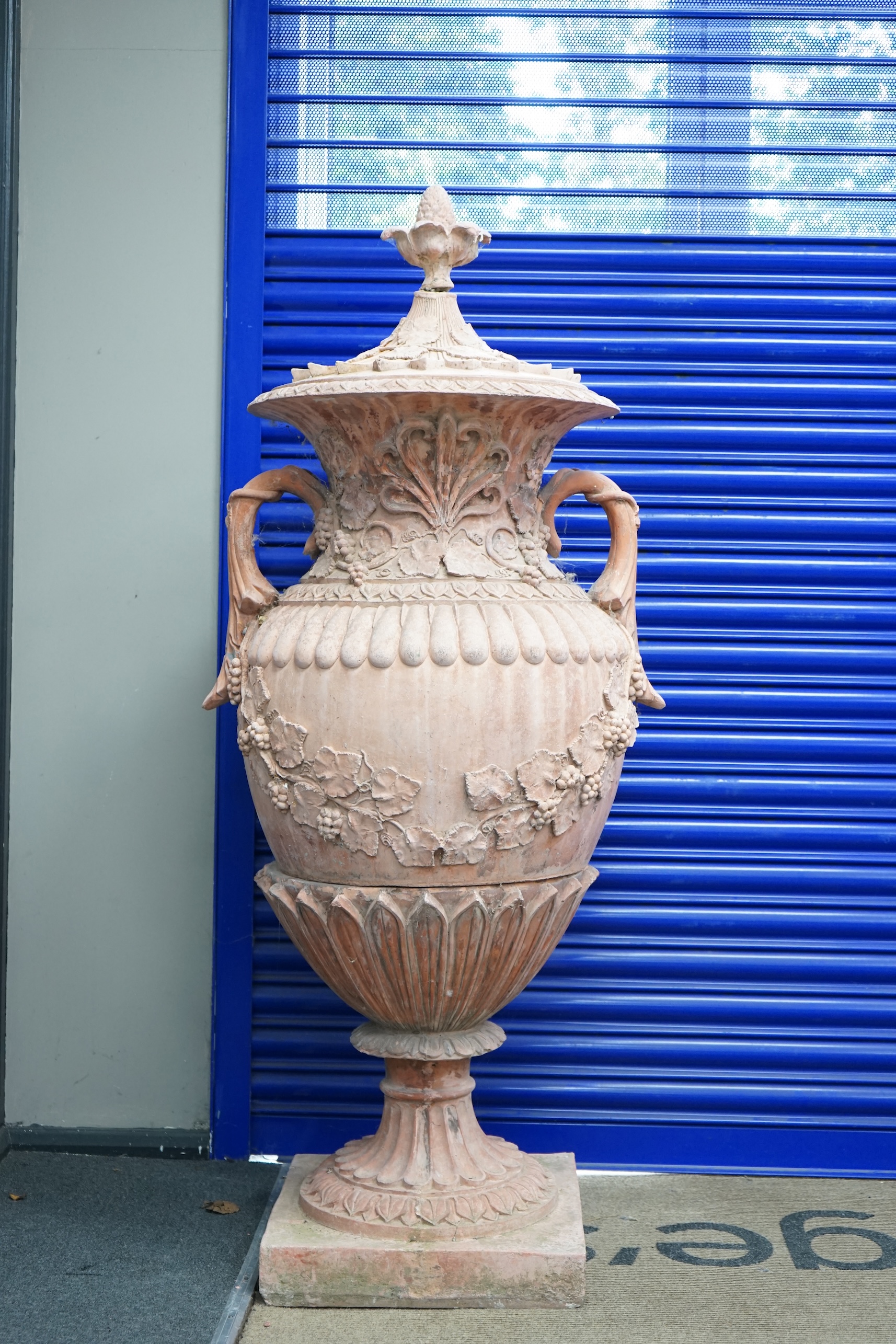 A pair of ornate terracotta urns and covers